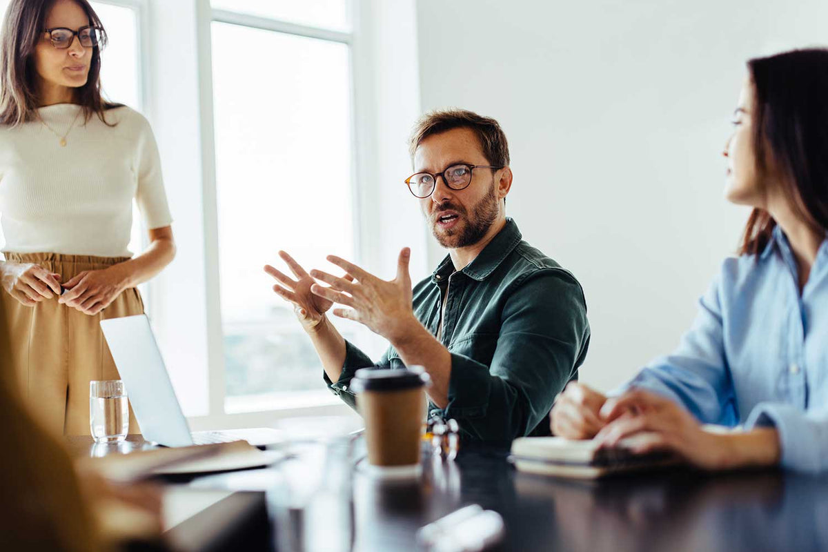 3 people in an office environment discussing what an employer of record is