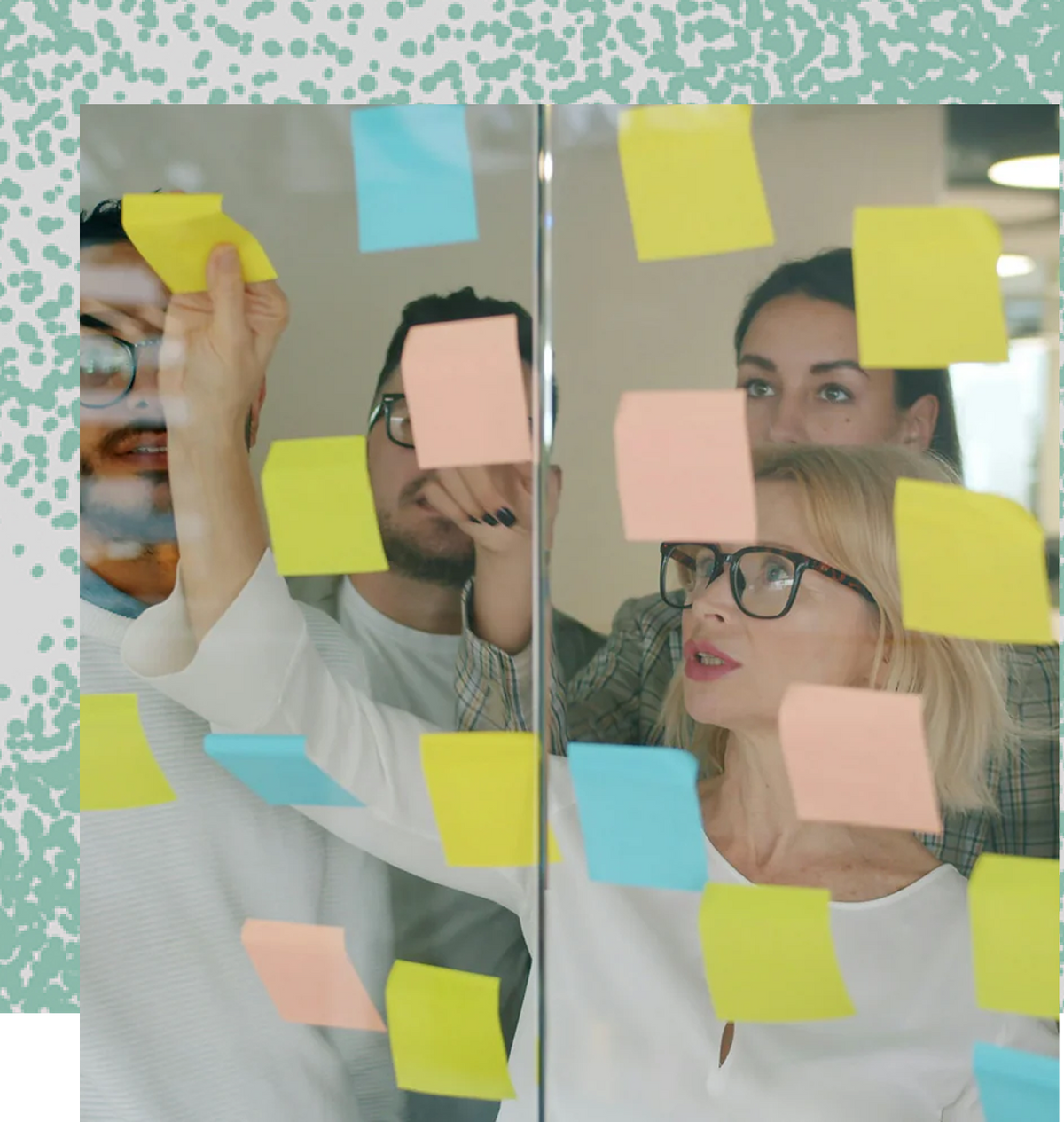 Group of people with colorful post-it notes on a glass wall