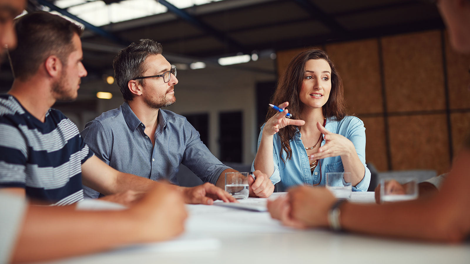 Group of people in a meeting room discussing something.
